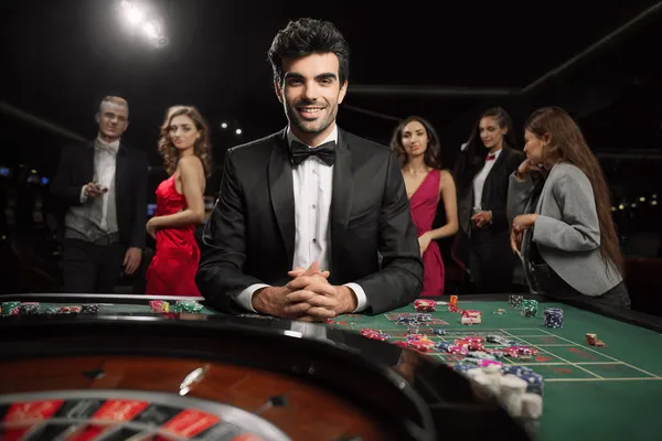 A glamorous woman holding casino chips in a neon-lit environment, representing the premium online casino atmosphere of JEETA.