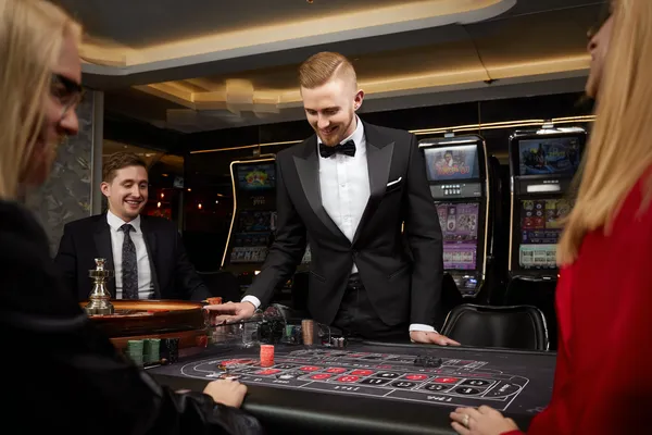 A stylish woman beside vibrant slot machines displaying glowing sevens, showcasing the variety of top slots at JEETA.