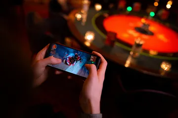 A player using their smartphone during a festive local event, representing JEETA’s fully mobile-friendly casino.